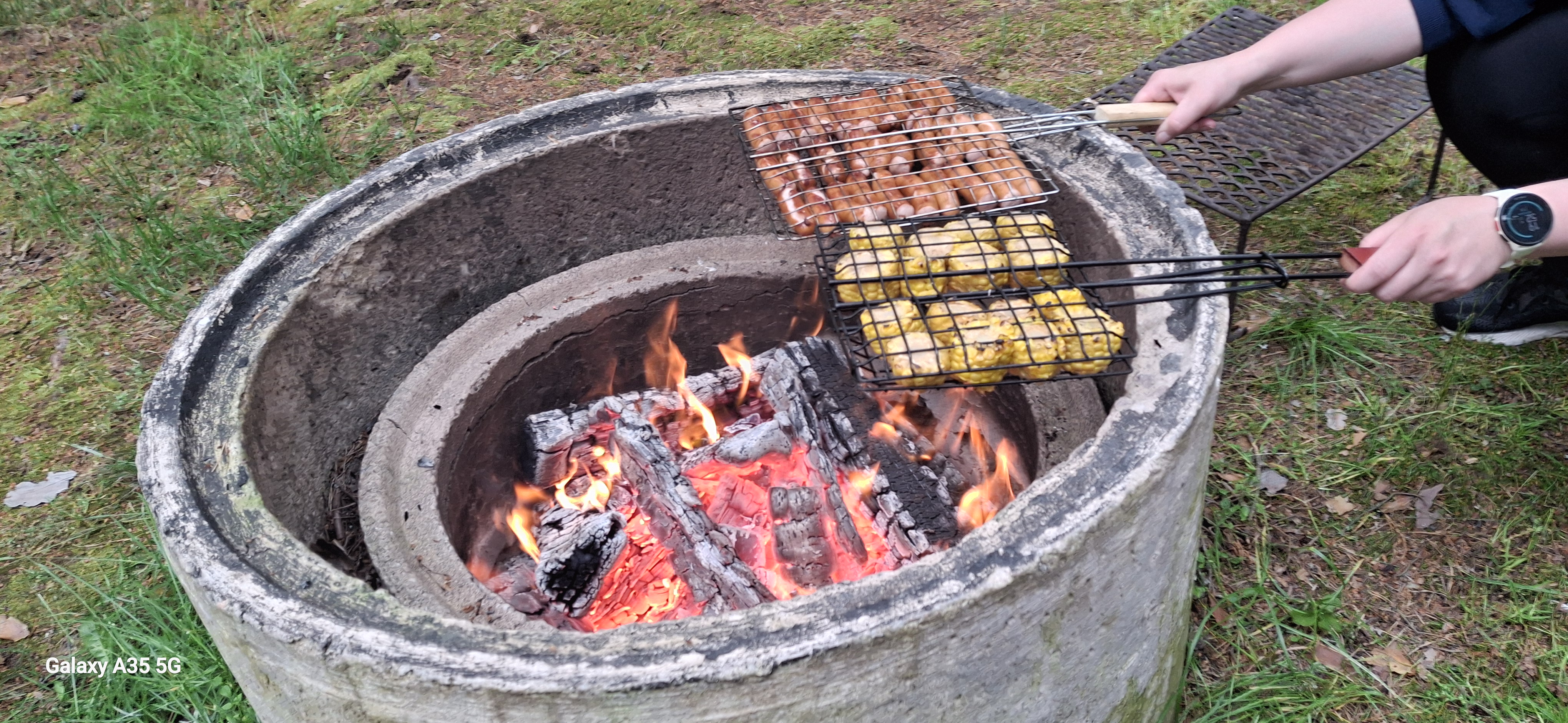 nuotiolla valmistetaan hot dog 